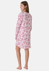 Pink nightgown with a heart pattern, long sleeves, and a loose fit. Made from soft fabric, ends above the knee.