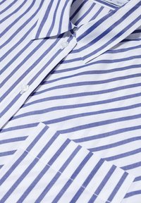 Chemise à col avec des rayures verticales bleues et blanches, avec des boutons blancs et une poche poitrine avant avec un motif à rayures assorti.