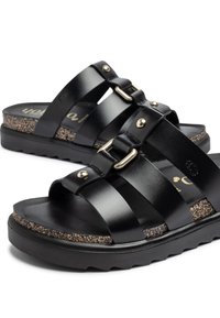 Sandali in pelle nera con multiple cinghie larghe, hardware dorato, una soletta in sughero testurizzato e una suola in gomma con righe.