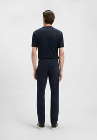 Marinblå kortärmad skjorta och matchande byxor med en slank design. Skjortan har rund halsringning, och byxorna har fickor både fram och bak.