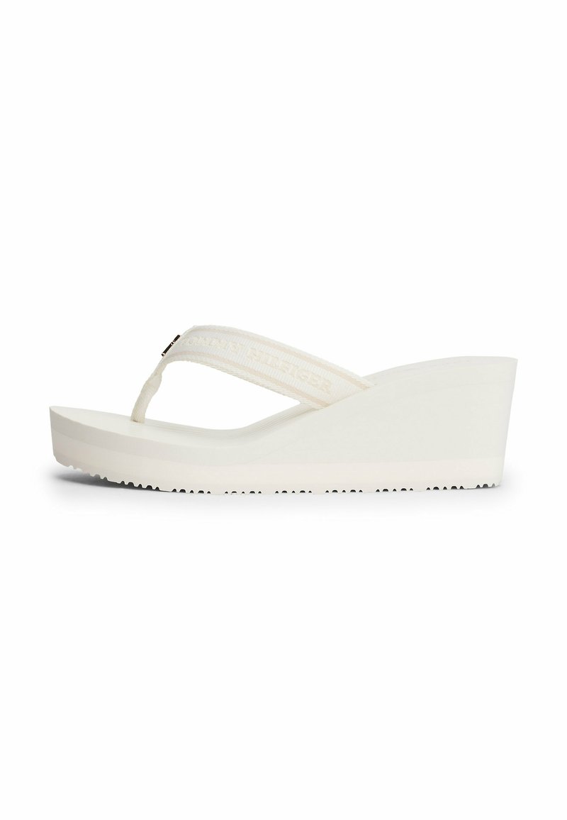 Witte platform flip-flops met een gewaxt bandje en reliëfbranding. Gladde wiggenhak en geprofileerde, gestructureerde zool voor grip.