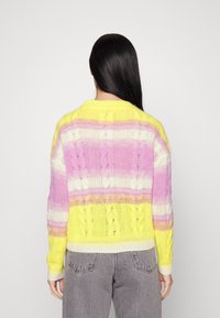 Vibrant knitted sweater featuring horizontal stripes in yellow, pink, and white with a loose fit and textured design.