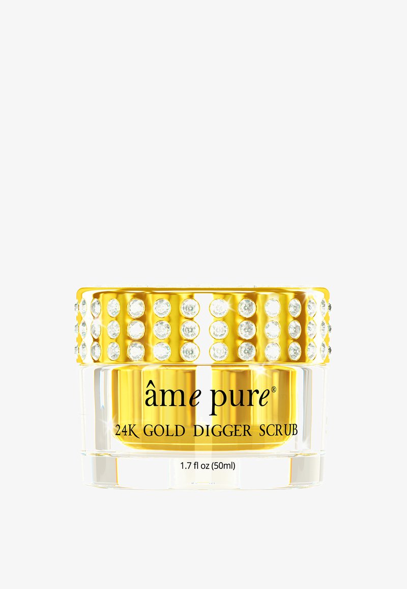 Durchsichtiger Glasbehälter mit einem goldenen Deckel, der mit runden Strasssteinen geschmückt ist. Das Etikett trägt die Aufschrift "âme pure 24K Gold Digger Scrub," 1,7 fl oz (50ml).