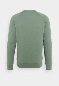 Sweat-shirt vert en tissu doux, avec un col rond, des manches longues raglan et un ourlet ainsi que des poignets côtelés.