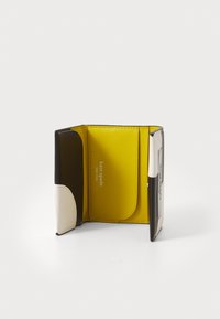 Dreifach gefaltete Geldbörse aus glattem Leder, mit gelben, braunen und cremefarbenen Paneelen. Geprägtes Logo im Inneren, mit mehreren Kartenfächern zur Organisation.