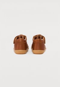 Bruna lädersandaler med öppen design, kardborrestängning och gummisålar. Slät struktur med sömmar på baksidan och sidorna.