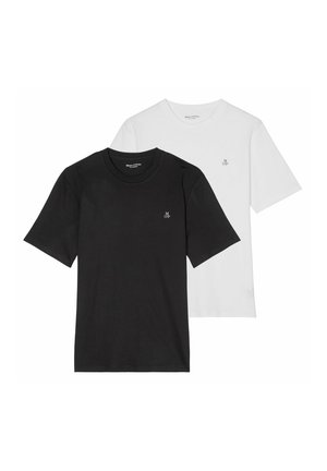 Primer plano de una camiseta blanca con letras negras "M O'P" impresas cerca de la zona del pecho en tela desgastada.