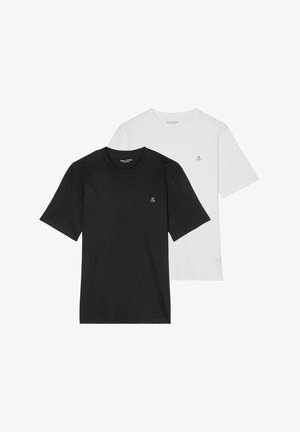 Primo piano di una t-shirt bianca con lettere nere "M O'P" stampate vicino all'area del petto su tessuto usurato.