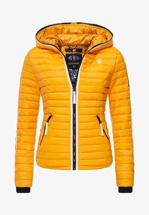 Sárga puffajak, kapucnival, függőleges tűzött mintázattal, fekete cipzárral, két oldalsó zsebbel és kontrasztos fekete-fehér díszítésekkel.