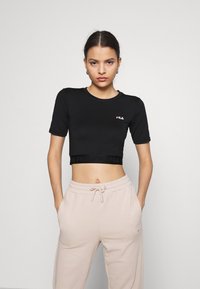 T-shirt nera corta con maniche corte e logo Fila in bianco e rosso. Il tessuto appare liscio, aderente e elasticizzato.