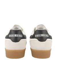 Valkoiset ja mustat tennarit, joissa on mokkanahkaa ja nahkaa, kumipohja ja "BIKKEMBERGS" -brändi kantapäällä. Klassinen matala muotoilu.