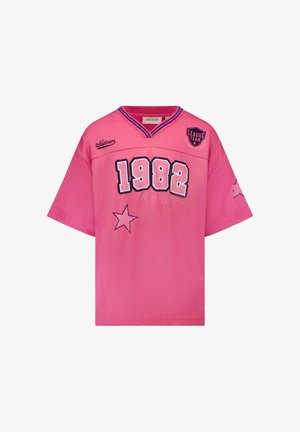 Roze shirt met korte mouwen, voorzien van een v-hals, '1982' opschrift, sterdetails en contrasterende blauwe biezen langs de halslijn.