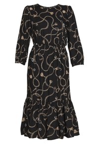 Svart klänning med kedje- och fransmönster, plisserad midja, trekvartsärmar och utsvängd fåll. Tyget verkar lätt och texturerat.
