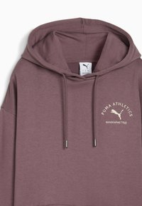 Hanorac purpuriu dintr-un material moale, cu glugă mare, buzunar frontal, șnururi de ajustare și logo-ul "PUMA ATHLETICS" bej pe pieptul stâng.