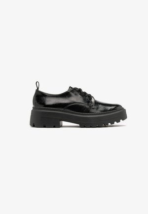 Scarpe in pelle verniciata nera con punta rotonda, design con lacci e suola spessa e chunky con scanalature profonde per la trazione.