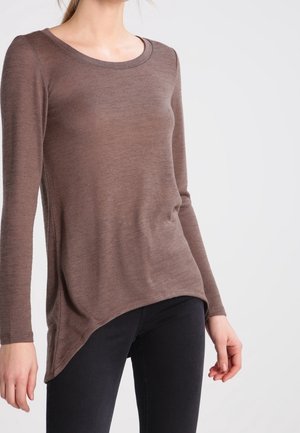 Maglia lavorata a maglia marrone a maniche lunghe con scollatura a barchetta, texture morbida, orlo asimmetrico e design aderente abbinata a jeans scuri.