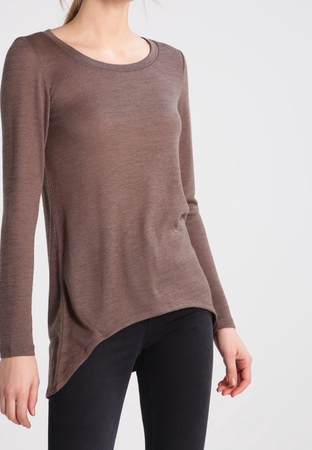 Braunfarbiges Langarmstrickoberteil mit Rundhalsausschnitt, weichem Material, asymmetrischem Saum und taillierter Passform, kombiniert mit dunklen Jeans.
