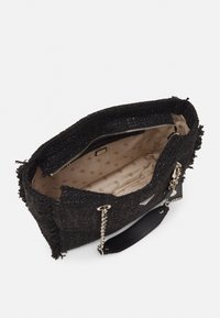 Czarna, pleciona torba wykonana z teksturowanej tkaniny, z złotym zamkiem, jasnym wnętrzem z małymi wzorami oraz łańcuchowymi akcentami na uchwytach.