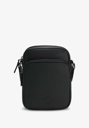 Musta nahkainen olkalaukku, jossa on teksturoitu pinta, vetoketjullinen pääosasto ja etutasku. Edessä kohopainettu logo.