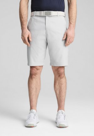 Light gray shorts made of synthetic material, featuring a flat front, side pockets, and a matching belt. Worn with white athletic shoes.