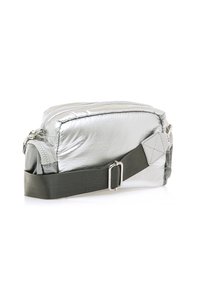 Silberne, reflektierende Stofftasche in rechteckiger Form, mit Reißverschlussverschluss und verstellbarem olivgrünem Tragegurt. Sie hat eine strukturierte Oberfläche und Metallbeschläge.