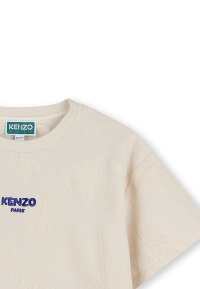 T-shirt en coton couleur crème avec des motifs de feuilles texturés, col rond, manches courtes, et "KENZO PARIS" brodé en bleu.
