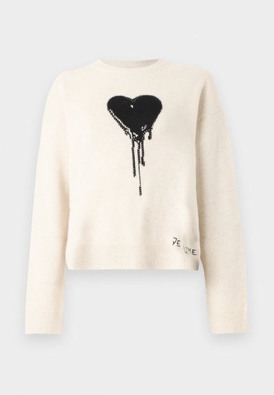 Pull à manches longues couleur blanc cassé avec un design de cœur noir coulant sur la poitrine et un petit texte "JE T’AIME" près de l'ourlet inférieur.