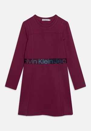 Bordowa sukienka z długim rękawem z okrągłym dekoltem, z kontrastującym teksturowanym paskiem w talii z logo "Calvin Klein Jeans". Gładka tkanina.
