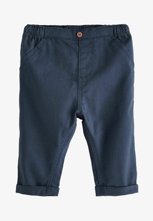 Donkerblauwe kinderbroek van glad katoen met een elastische tailleband, voorzakken en opgerolde boorden. Houten knoopdetail bij de taille.