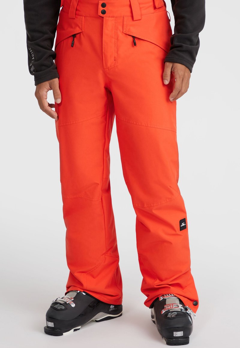 Feloranje skibroek met een duurzaam materiaal, voorzien van twee voorzakken, versterkte knieën en een zwart logo-detail aan de zijkant.