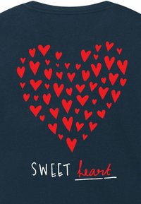 Tamsiai mėlynas marškinėlis su raudonu širdies grafiku, sudarytu iš mažesnių širdelių, o žemiau yra tekstas "SWEET heart" baltomis ir raudonomis raidėmis.