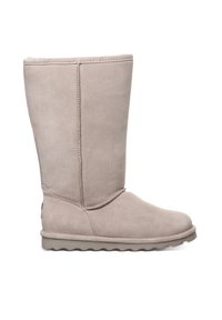 Beige Wildlederstiefel bis zum Knie mit abgerundeter Zehenpartie, weicher Innenausstattung und einer strukturierten Gummisohle mit Wellenmuster.
