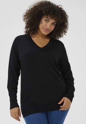 Black V-neck sweater in a soft knit material with long sleeves and ribbed cuffs, paired with blue fitted jeans.