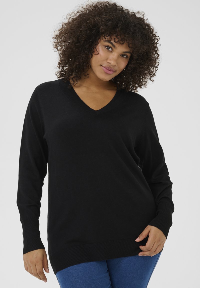 Black V-neck sweater in a soft knit material with long sleeves and ribbed cuffs, paired with blue fitted jeans.