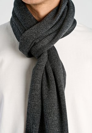 Donkergrijze gebreide sjaal om de hals gewikkeld, met een gestructureerd patroon. Het materiaal lijkt zacht en van gemiddelde dikte.