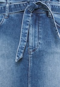 Ljusblå denimshorts med en knuten bälte i midjan, med blekta fläckar och en jämn yta. Femficksdesign och bältesloopar.