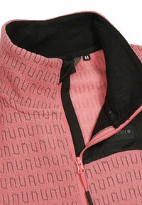 Fleece-pullovrar i mjuk rosa med mönstrad textur. Har en hög krage, svart foder och rosa dragkedja med en medieficka och etikett inuti.
