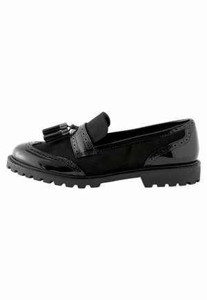Black loafers made of suede and patent leather. Features decorative tassels, brogue detailing, and a rugged rubber sole.
