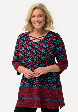 Tunique noire avec un motif floral rouge et bleu, encolure ronde avec un détail en croix, et manches trois-quarts avec des bandes d'accent.