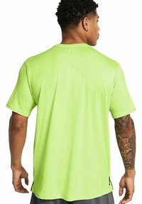 Maglietta atletica a maniche corte di un brillante verde neon, realizzata in tessuto liscio, con un colletto senza etichetta e fessure laterali per il comfort.