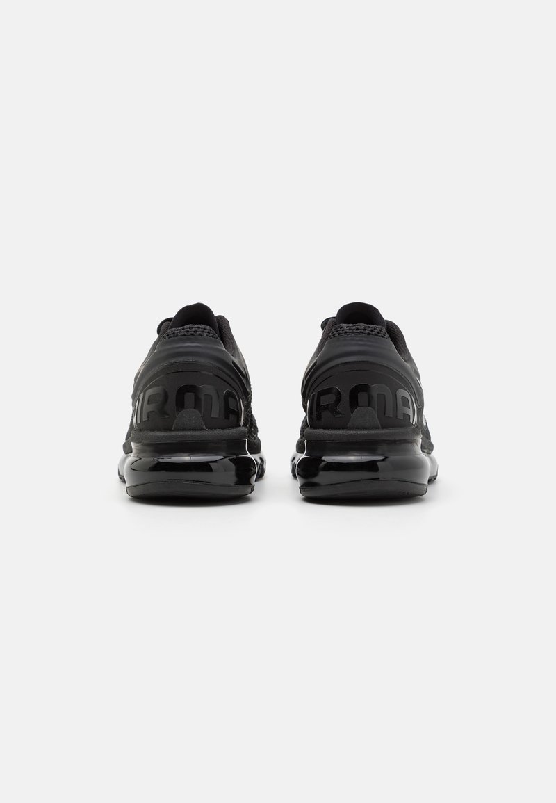 Baskets de sport noires présentant un dessus texturé, des panneaux en maille et une semelle noire brillante. Le talon arbore une marque en relief.