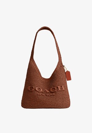 Brūna austā plecu soma ar uzrakstu "COACH New York" un mazu pievienotu birku labajā pusē.