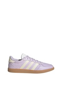 Baskets Adidas basses de couleur violet clair avec des bandes blanches et un talon beige, posées sur une semelle en caoutchouc couleur gomme, vue de profil.