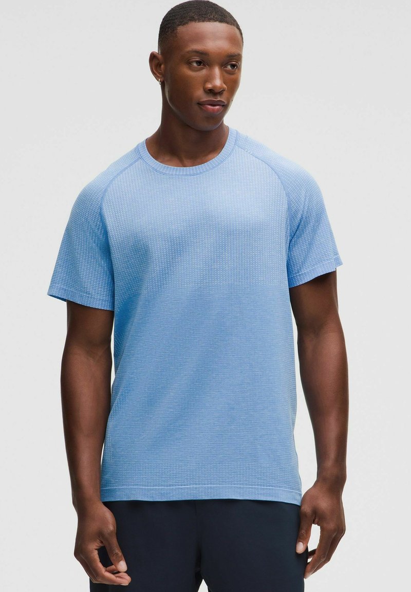 Hellblaues Kurzarm-T-Shirt mit strukturiertem Muster, Rundhalsausschnitt und Raglanärmeln. Der Stoff scheint weich und atmungsaktiv zu sein.
