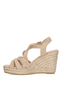 Sandalias de cuña en ante beige claro con tiras entrecruzadas, plantilla envuelta en yute y un tacón de cuña texturizado. Incluye una correa ajustable para el tobillo.
