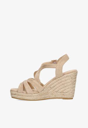 Sandalias de cuña en ante beige claro con tiras entrecruzadas, plantilla envuelta en yute y un tacón de cuña texturizado. Incluye una correa ajustable para el tobillo.