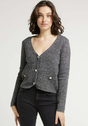 Cardigan gris en tricot avec un décolleté en V, tissu texturé et trois gros boutons. Il dispose de deux poches avant et d'un ourlet court.