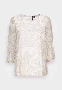 Blusa leve e semi-translúcida em tom bege com padrões de folhas brancas. Possui decote redondo e mangas 3/4 bufantes. Detalhe de abertura nas costas.