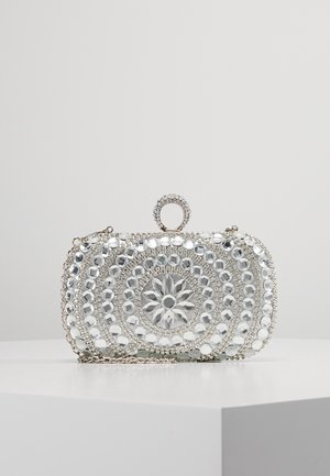 Rechthoekige zilveren clutch met ronde spiegelparelpatronen en een met juwelen bezette sluiting op een witte ondergrond.