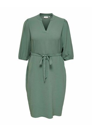 Grønn knelengde kjole med teksturert stoff, 3/4 puffermer, hakket utringning og belte knyttet i midjen.